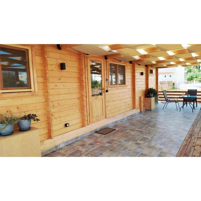 - une terrasse couverte couverte avec une table et des chaises dans l'établissement Fillip wooden house, à Prévéza