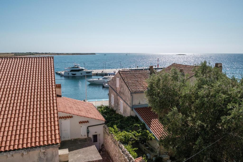 un groupe de bâtiments et un bateau dans l'eau dans l'établissement House Mateja Unije, à Unije