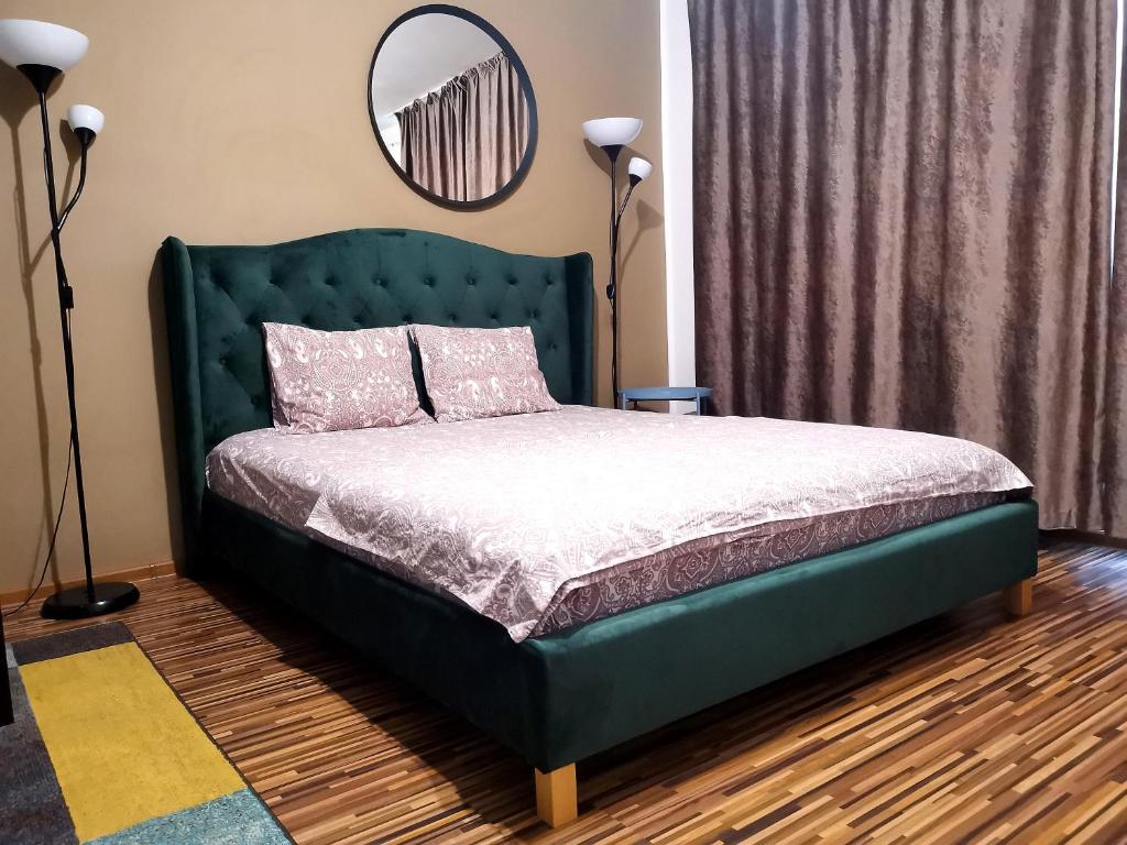 1 cama con cabecero verde en un dormitorio en Coffee Residence, en Bucarest