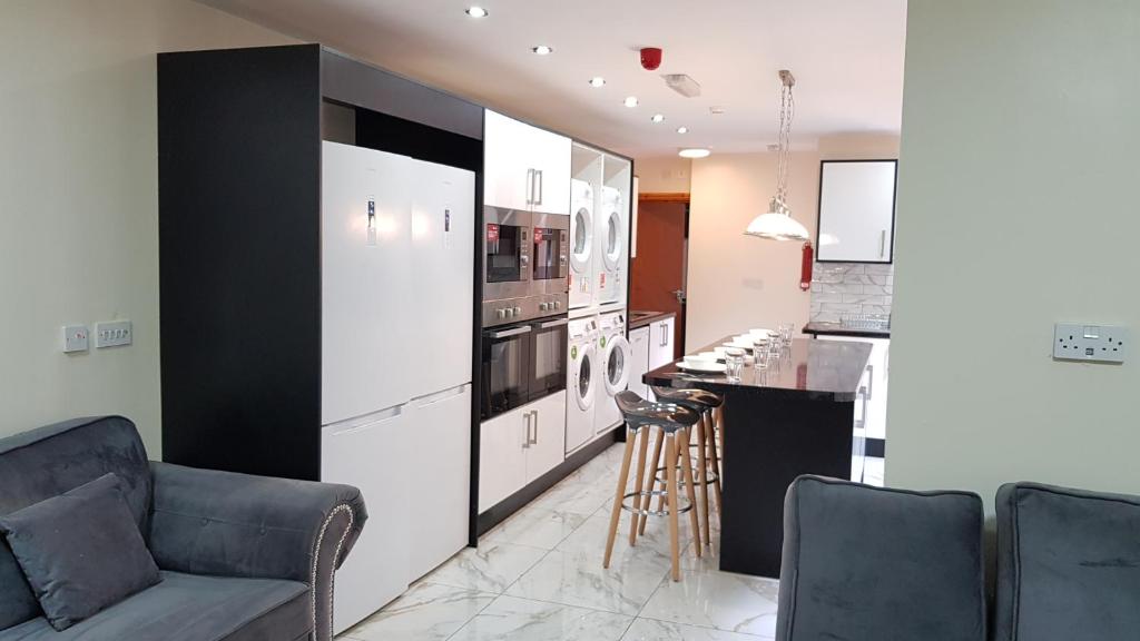 a kitchen with a couch and a counter in a room at Double Ensuite Rooms Near City Centre in Birmingham