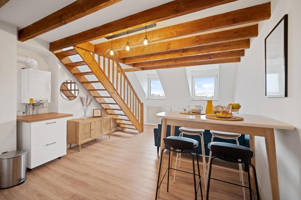 a kitchen with a table and chairs and a staircase at La Douce Échappée, 2 Pers, Bien Situé in Boulogne-sur-Mer