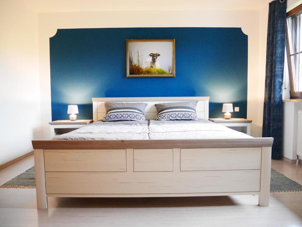 1 dormitorio con 1 cama grande y pared azul en Ferienwohnung Eichkatzel, en Zell