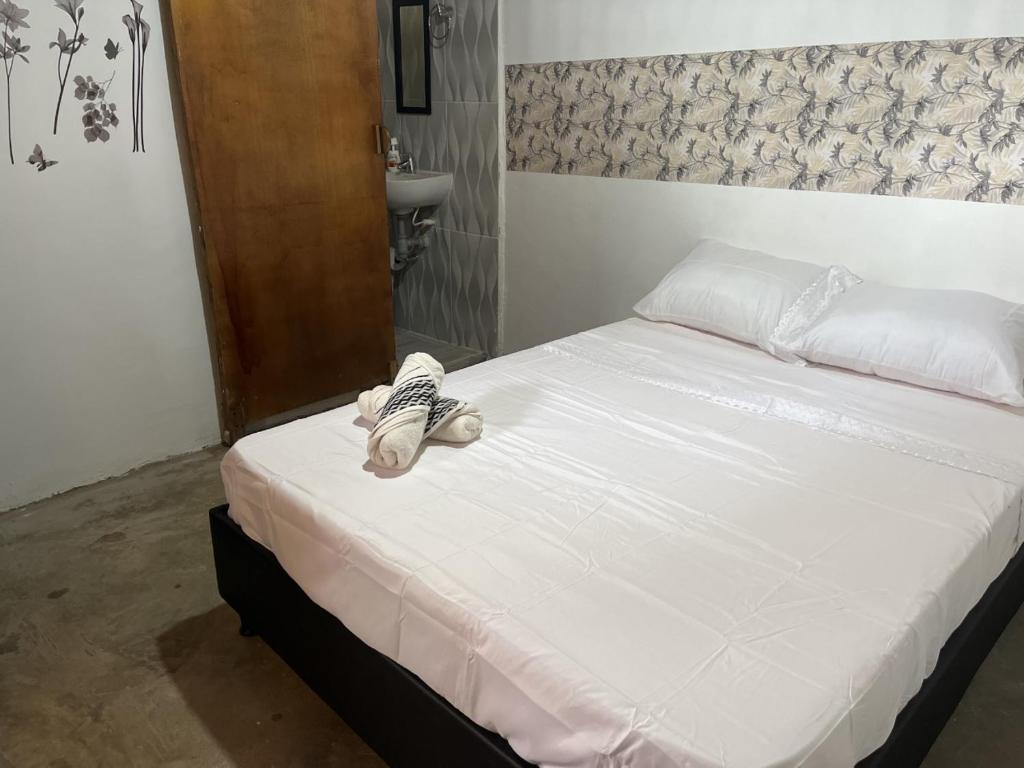 un letto con un paio di scarpe sopra di PALOMINO PLAZA HOSTEL a Palomino