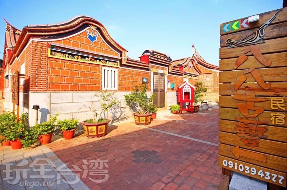 a sign in front of a brick building at 八八古藝民宿 in Jinning