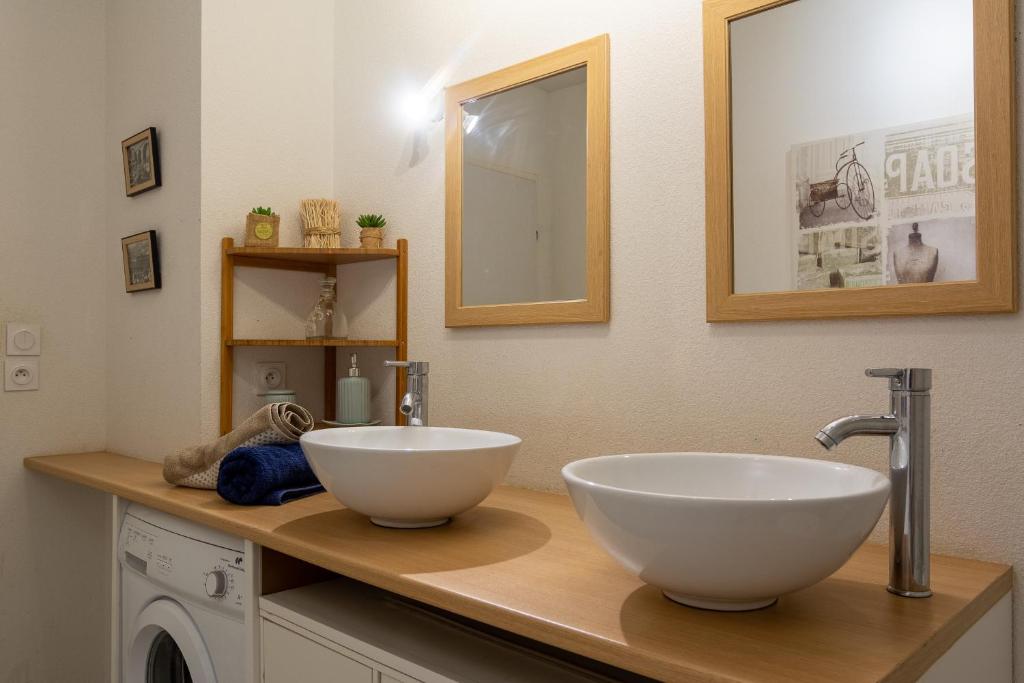 a bathroom with two white bowls on a counter at Appart cosy(4pers)PARKING CLIM Terrasse Vélodrome in Marseille