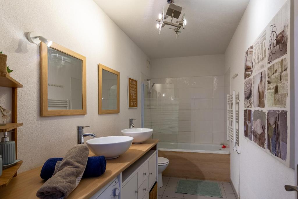 a bathroom with two sinks and a tub at Appart cosy(4pers)PARKING CLIM Terrasse Vélodrome in Marseille
