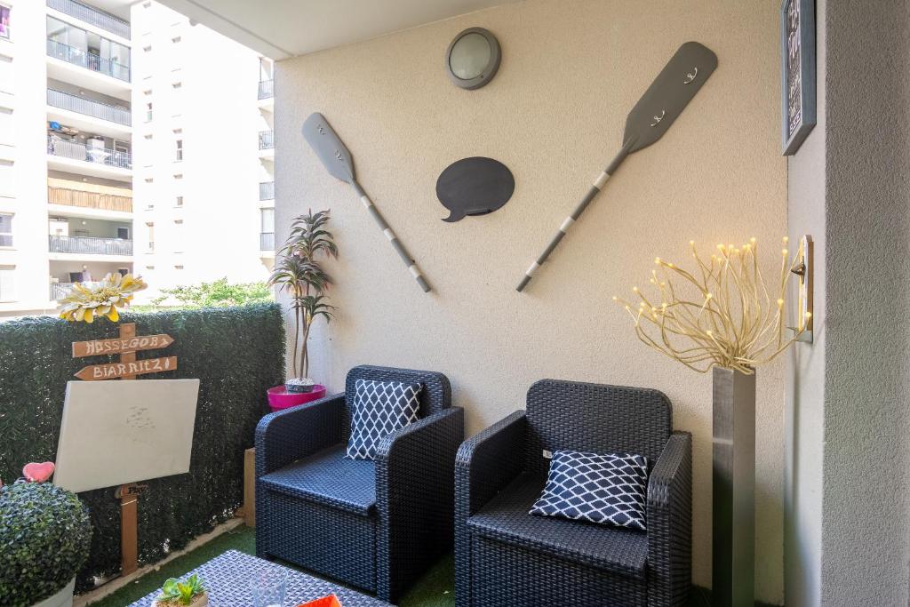 a patio with two chairs and a clock on the wall at Appart cosy(4pers)PARKING CLIM Terrasse Vélodrome in Marseille