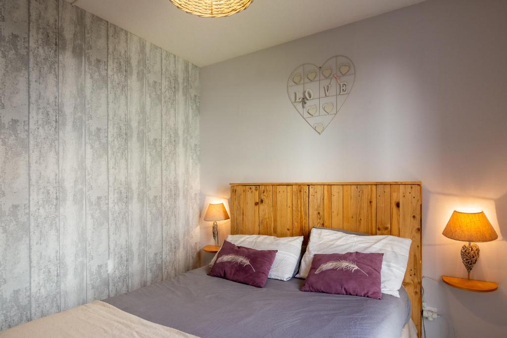 a bedroom with a bed with two lamps and a heart on the wall at Appart cosy(4pers)PARKING CLIM Terrasse Vélodrome in Marseille
