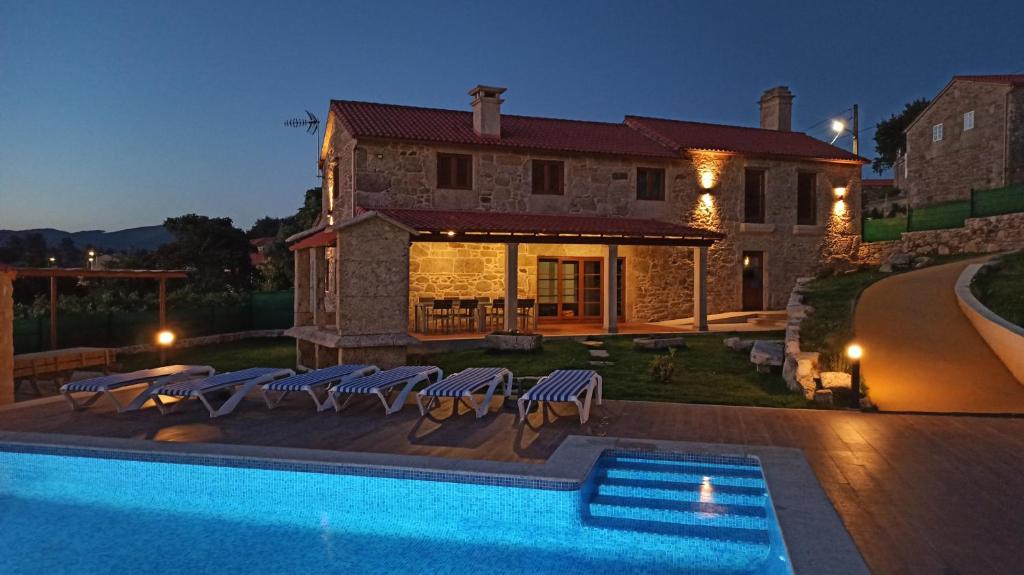 una casa con piscina frente a una casa en Veiga da Porta - Casa Rural, en Ciquiril