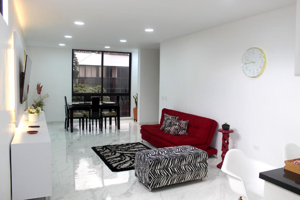 sala de estar con sofá rojo y mesa en Apartamento Omnia, amoblado y cómodo., en Bucaramanga
