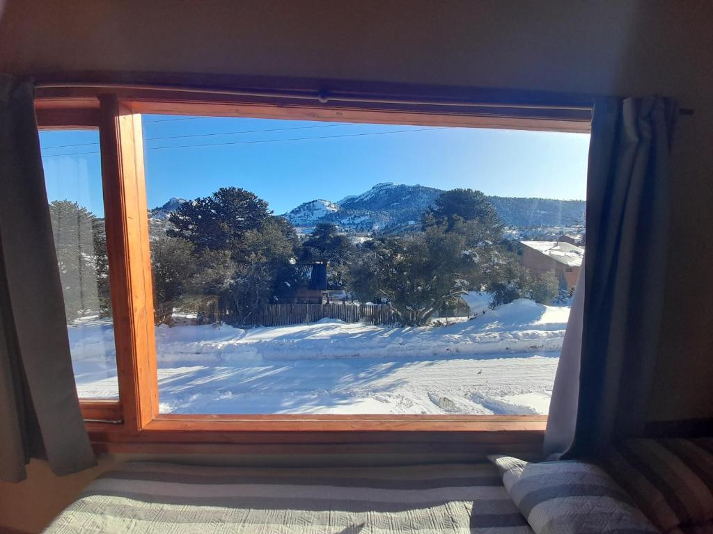 a window with a view of a snow covered yard at Lago Mistico in Villa Pehuenia