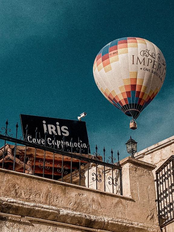 a hot air balloon flying over a building at Iris Cave Cappadocia in Ortahisar