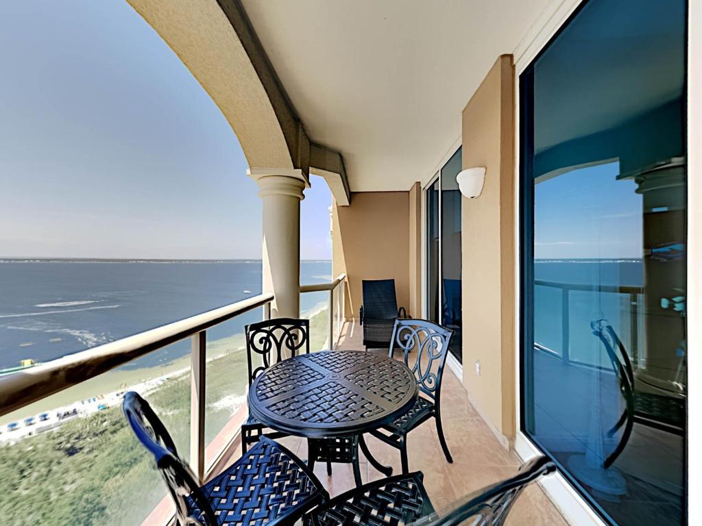 a balcony with a table and chairs and the ocean at Portofino Island Resort #2-1608 in Pensacola Beach