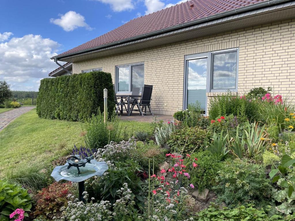 a garden in front of a house with flowers at Holiday home Wiesenblick in Dobbertin in Dobbertin
