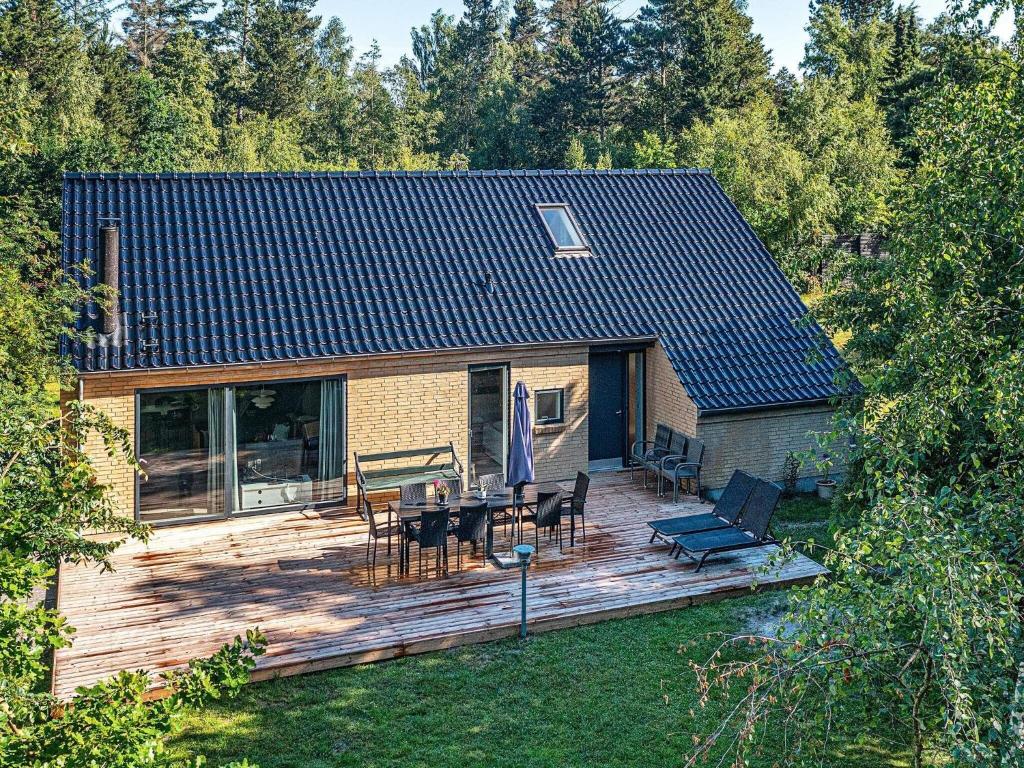 Casa con terraza de madera con mesa y sillas en 10 person holiday home in V ggerl se, en Bøtø By