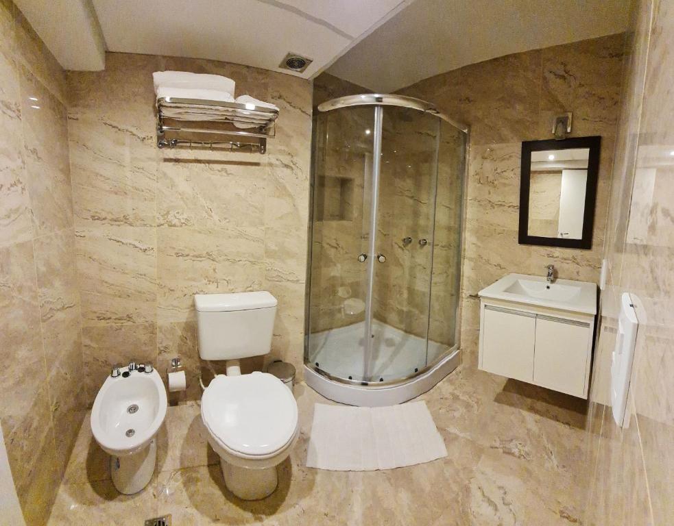 een badkamer met een douche, een toilet en een wastafel bij Departamento a metros de la Peatonal in Mendoza