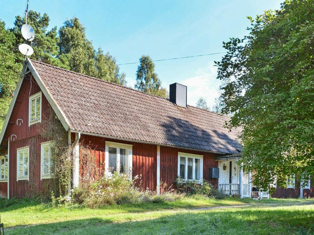 una casa roja con techo de gambrel en 8 person holiday home in L NSBODA en Ubbaboda