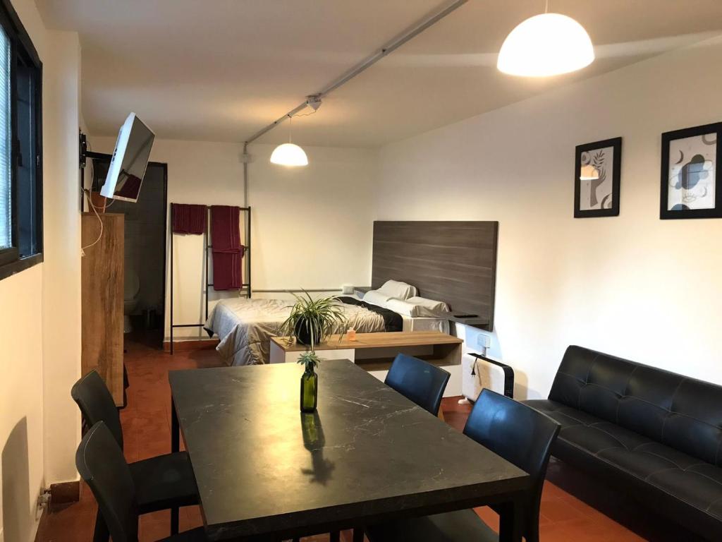 sala de estar con mesa y cama en Departamento privado en Casa Barranca Yaco en Córdoba