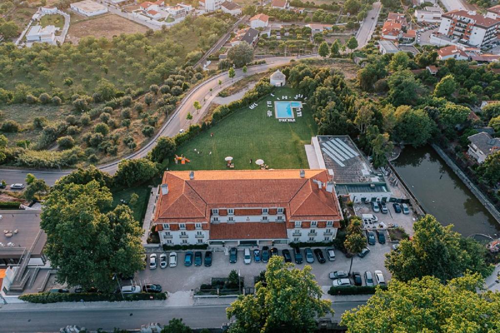 - une vue de tête sur un grand bâtiment avec un parking dans l'établissement Conimbriga Hotel do Paço, à Condeixa-a-Nova