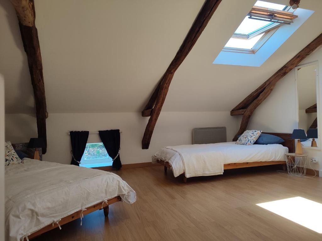 sypialnia na poddaszu z 2 łóżkami i świetlikiem w obiekcie A deux pas de St Cirq Lapopie , Gite des Murets de l'isa w mieście Esclauzels