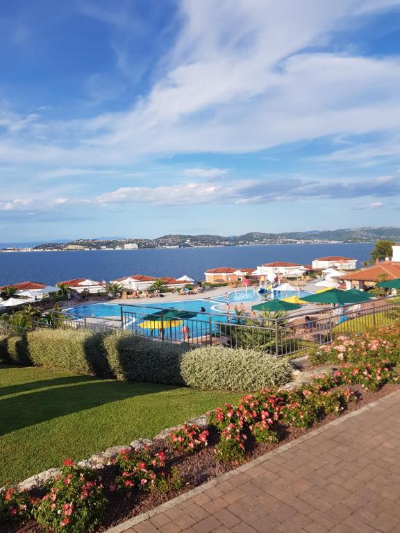 a resort with a pool and the ocean in the background at Apartment with a sea view in Skiper resort in Crveni Vrh