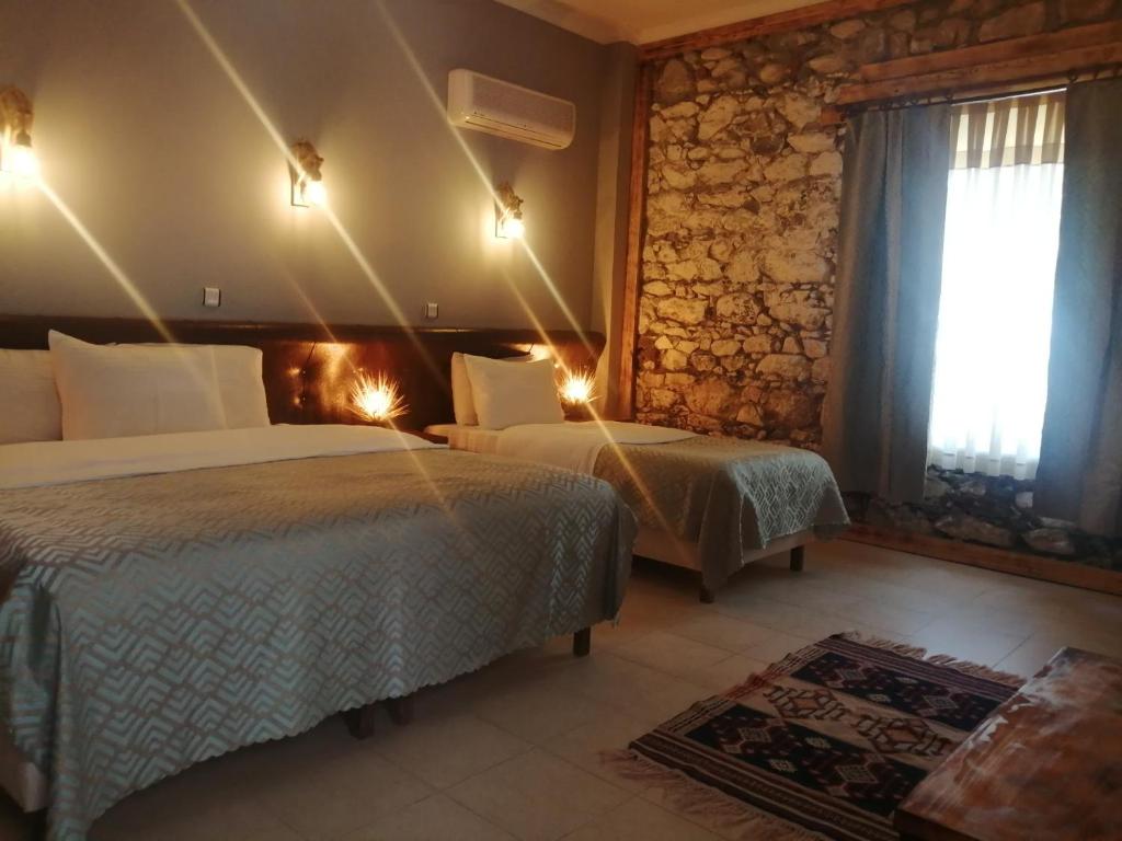 a hotel room with two beds and a fireplace at Bacahan Hotel in Altınoluk
