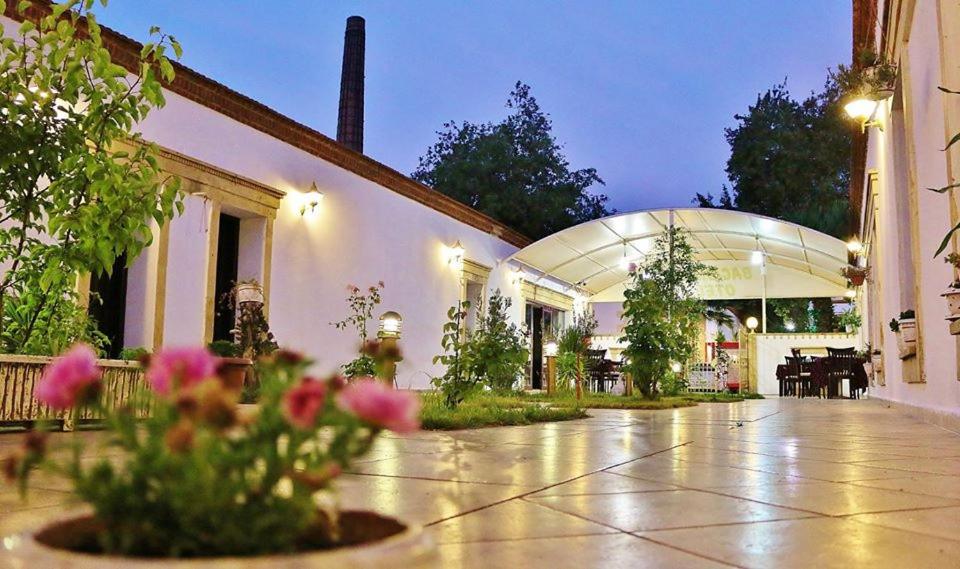 un patio de un edificio con flores en un jarrón en Bacahan Hotel, en Altinoluk