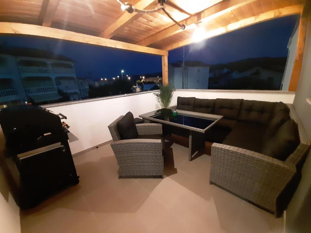 salon z kanapą i krzesłami na balkonie w obiekcie Apartman Mate Lopar w mieście Lopar