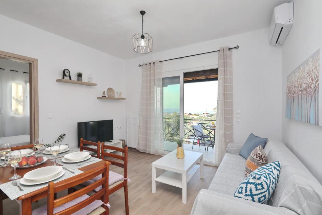 ein Wohnzimmer mit einem Sofa und einem Tisch in der Unterkunft Esperides apartments Arethousa in Skopelos