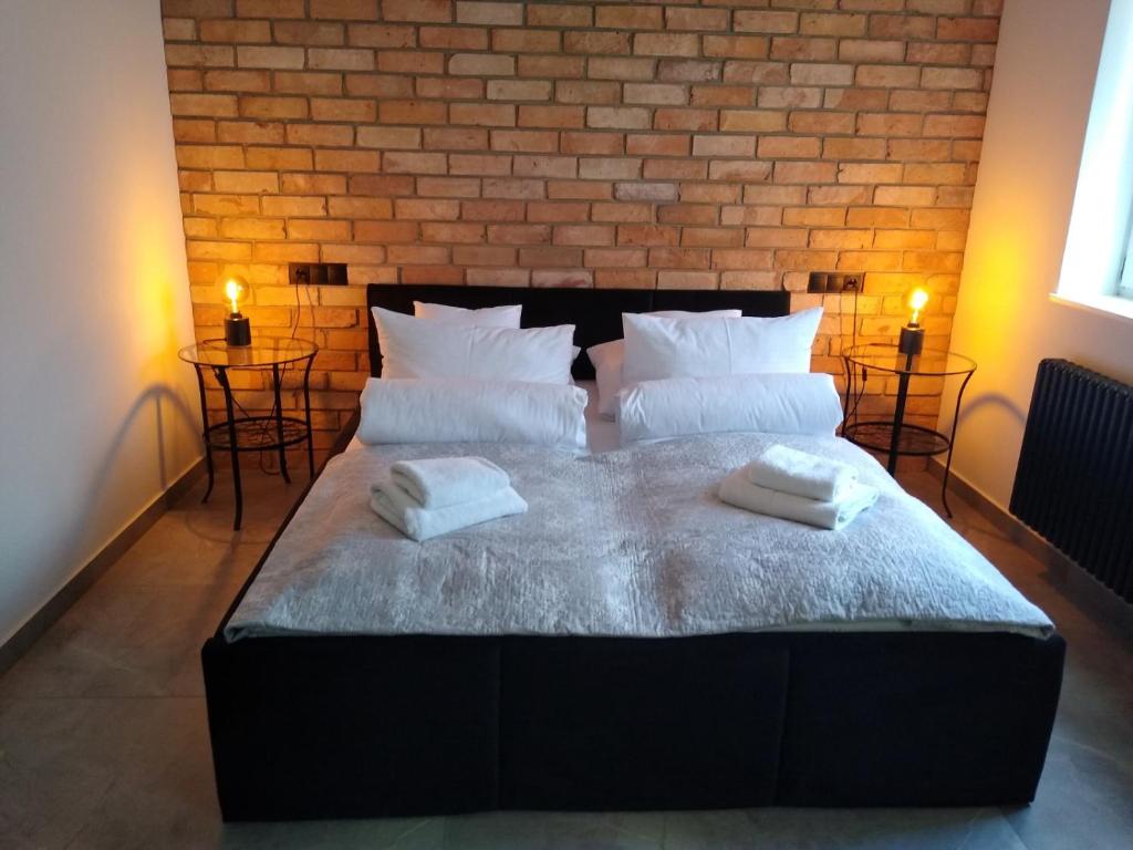 a bedroom with a large bed with two towels on it at Apartament LOFT in Ostróda