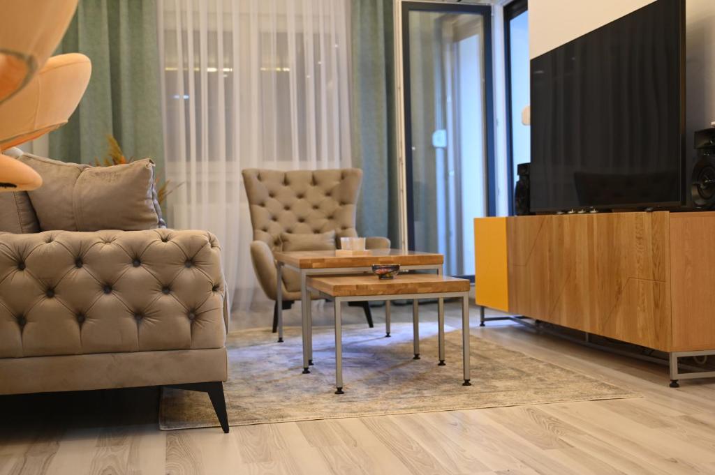 sala de estar con sofá, mesa y TV en Apartman Mosaic, en Doboj