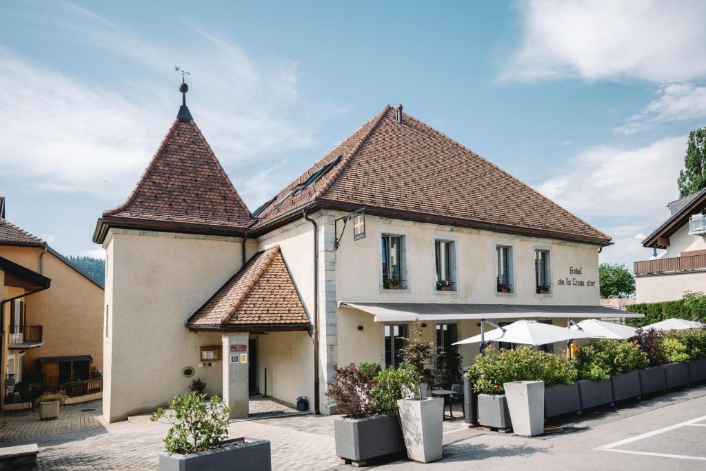 um edifício com duas torres numa rua em Hotel-Restaurant La Croix d’Or em Ballaigues