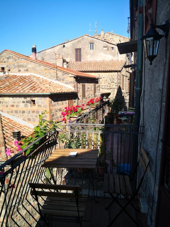 balkon ze stołem i krzesłami na budynku w obiekcie La Gioiosa w mieście Radicofani