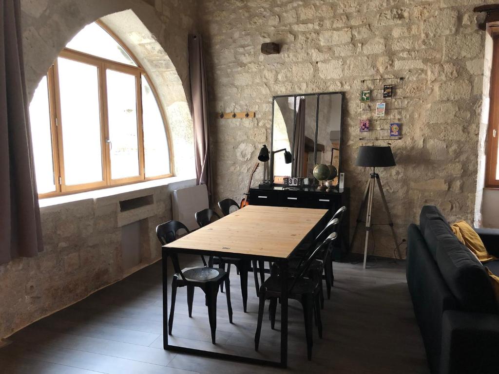 Loft de charme centre de Montcuq في Montcuq: غرفة طعام مع طاولة وكراسي خشبية