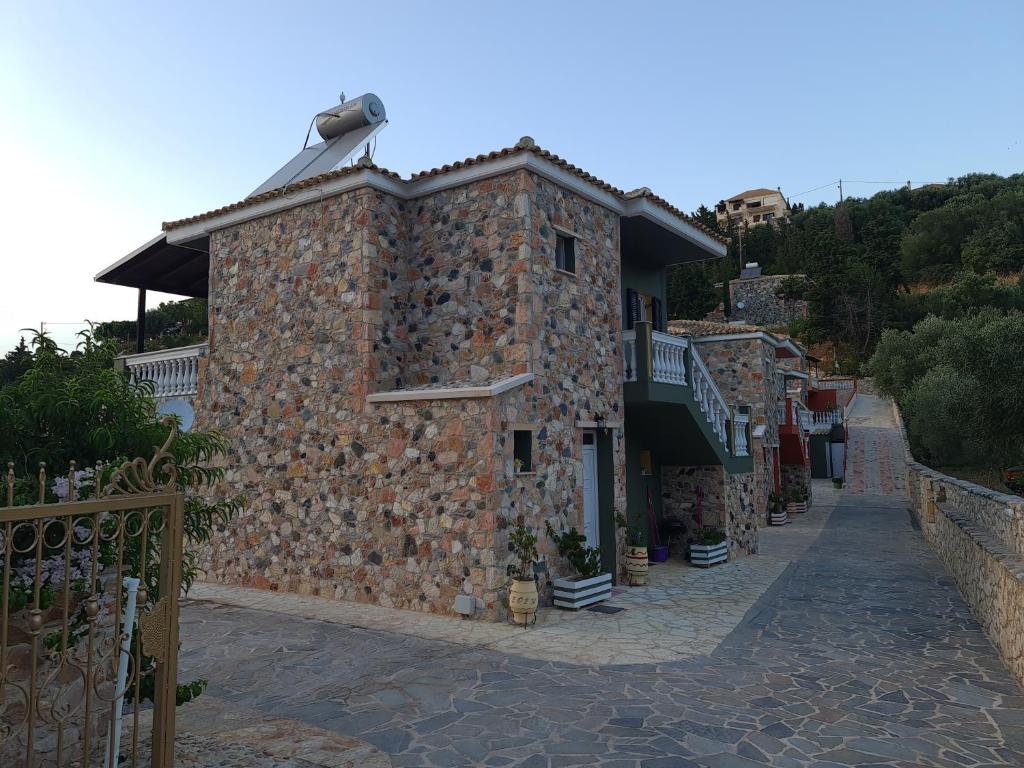 a stone building on a hill next to a street at Edem Studios in Syvota