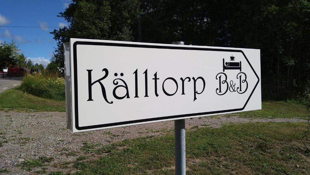 a white sign for a markup box on a road at Torp Källtorp B&B in Kisa