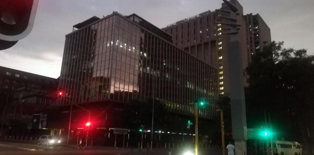 een groep hoge gebouwen met rode verkeerslichten bij Just a Room in Pretoria