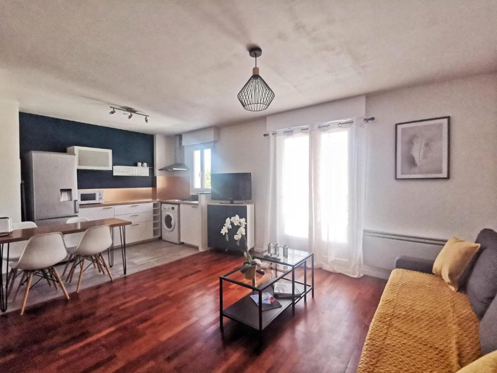 een woonkamer met een bank en een tafel bij Le 100 Brossolette in Noisy-le-Grand