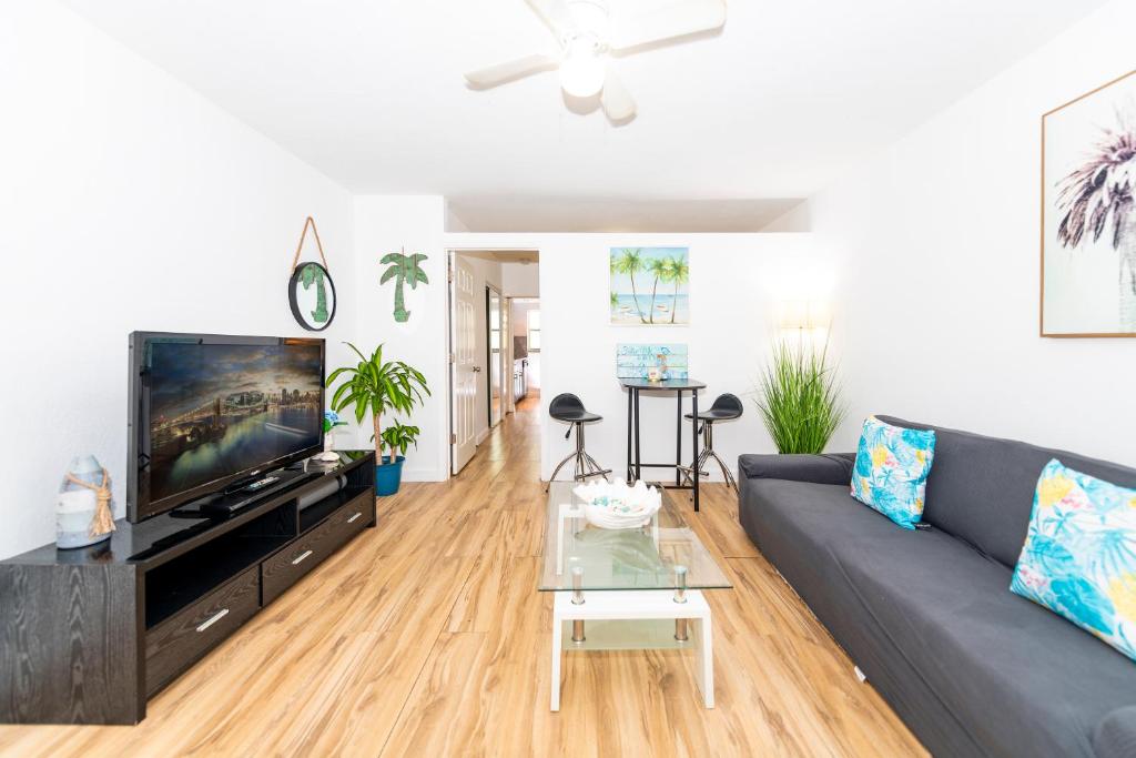 a living room with a gray couch and a tv at South Beach Apartments in Miami Beach