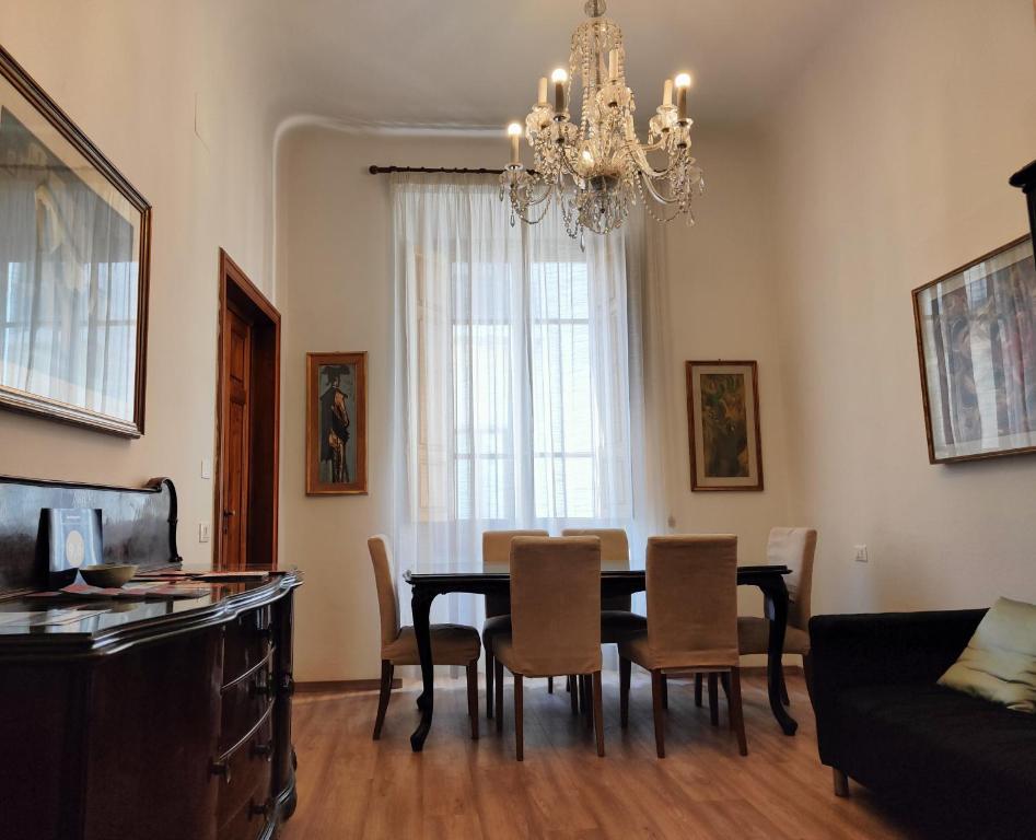 une salle à manger avec une table, des chaises et un lustre dans l'établissement Accanto al Duomo, à Florence