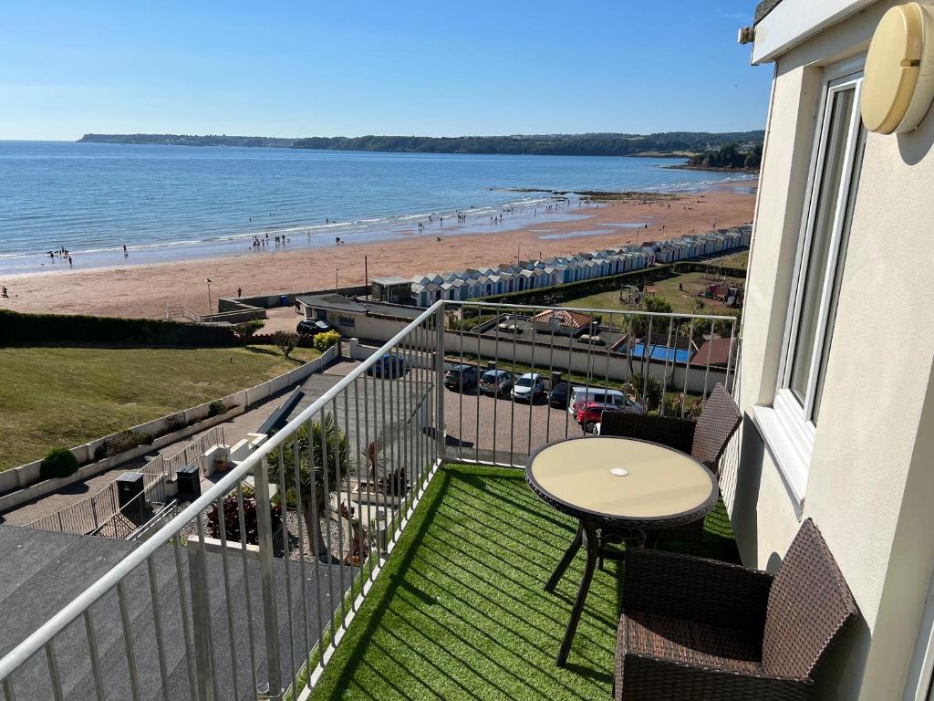 a balcony with a table and a view of the beach at Vista Apartments, Goodrington Beach, Paignton in Paignton