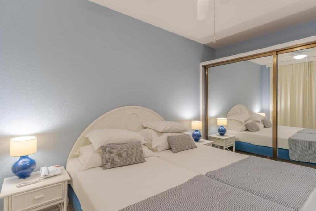 - une chambre avec 2 lits et un miroir dans l'établissement Atlantic Gardens Beach - atlanticgardensbeach com, à Funchal