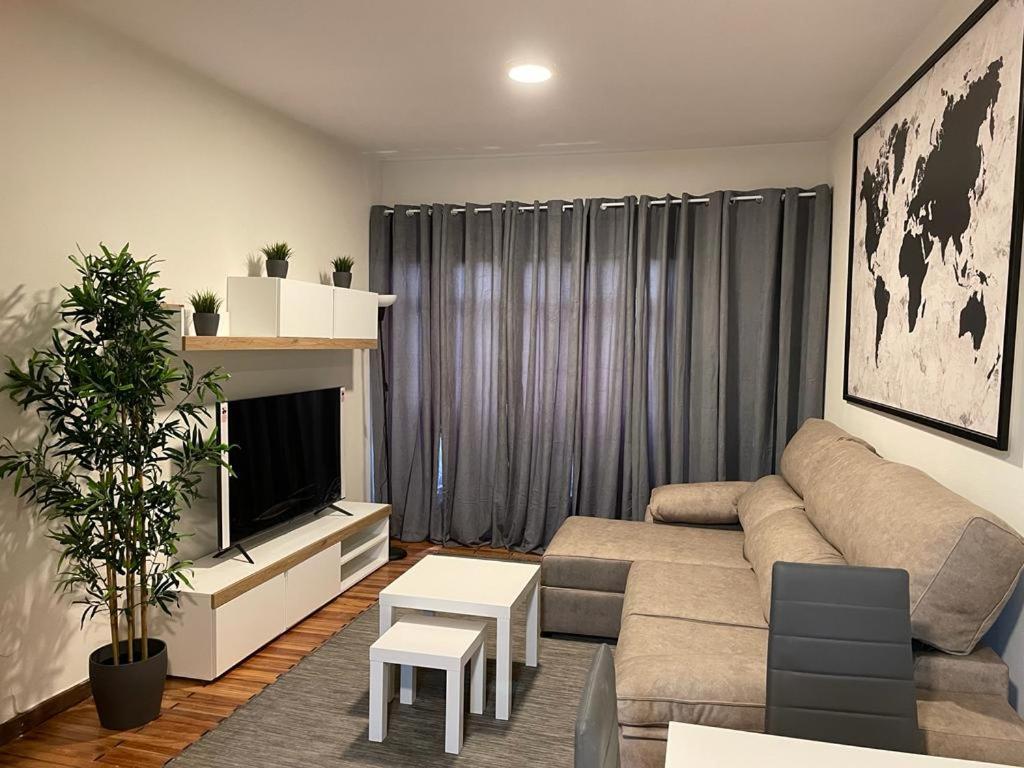 a living room with a couch and a tv at MSuites Viveiro in Viveiro