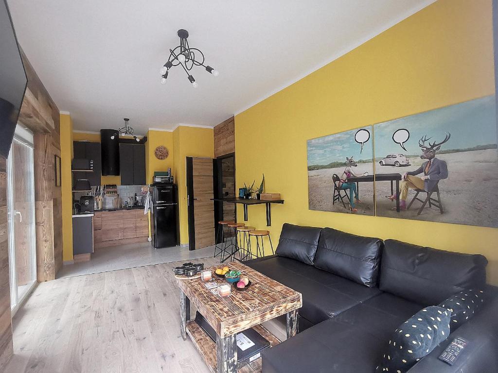 a living room with a black couch and a table at The Pop Art Apartment in Katowice