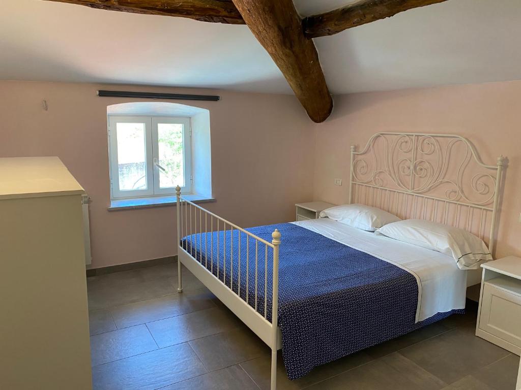 een slaapkamer met een bed en een raam bij Villa Lucia home holiday in Carrodano Inferiore