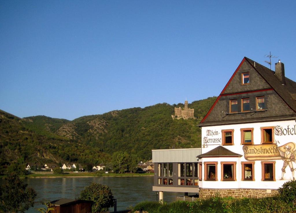a building on the side of a body of water at Weinhotel Landsknecht in Sankt Goar