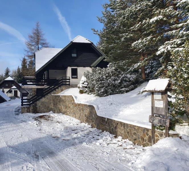 ein Haus im Schnee mit einem Schild davor in der Unterkunft Chalet Anita Rogla in Zreče