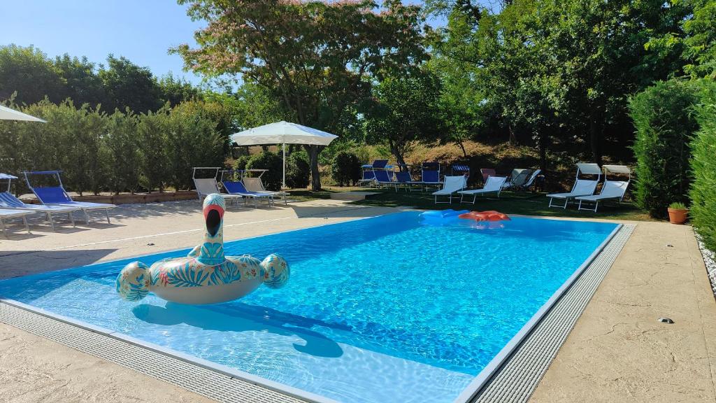 a swimming pool with a swan in the water at Corte Bussari in Arquà Polesine