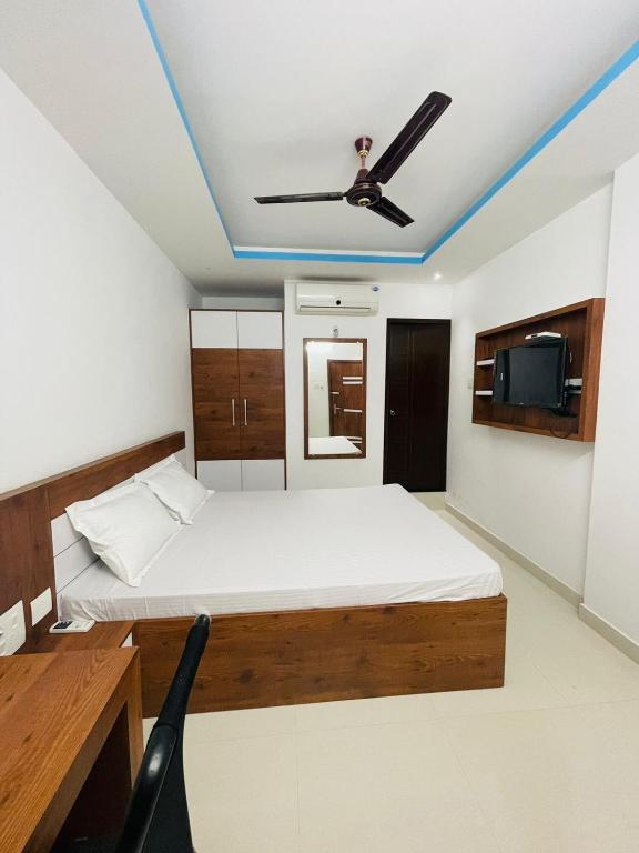 a bedroom with a bed and a ceiling fan at Zam Zam Residency in Cheruppulasseri