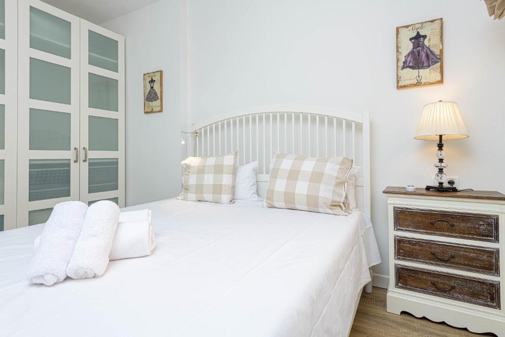 biała sypialnia z białym łóżkiem i komodą w obiekcie WintoWinRentals Genial Apartamento, Céntrico y Silencioso w Maladze